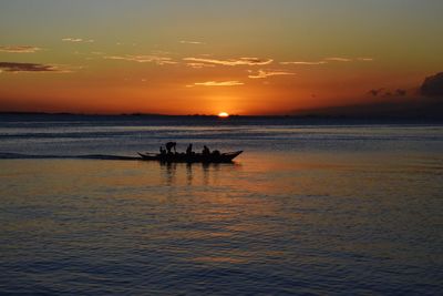 Silhouette boat in sea against sky during sunset