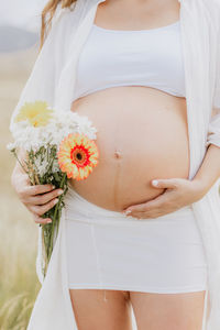 Midsection of bride holding bouquet