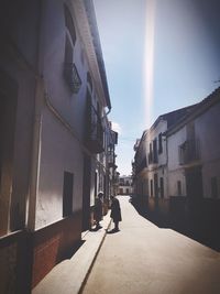 Rear view of people walking on street in city