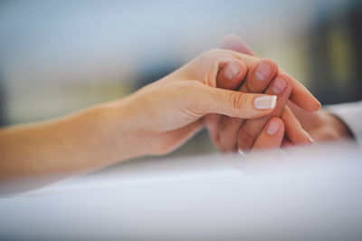 Cropped image of man holding woman hand