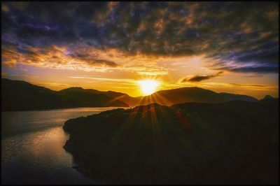 Scenic view of sea against dramatic sky during sunset