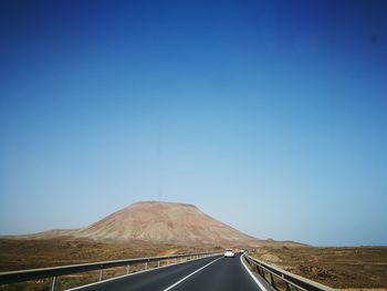 Road against clear blue sky