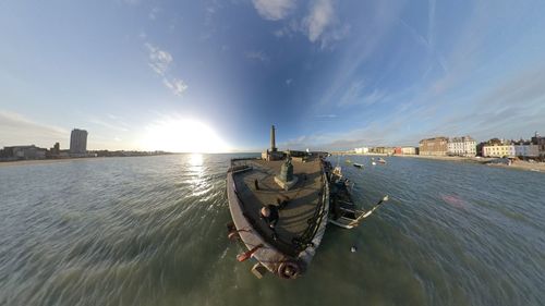 Man in sea against sky in city