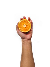 Close-up of hand holding apple against white background