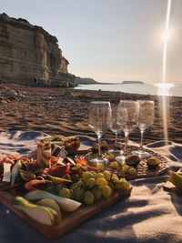 Fruits on beach by sea against sky during sunset