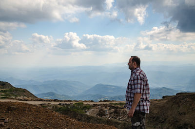 Man standing on mountain against sky