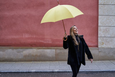 Rear view of woman holding umbrella