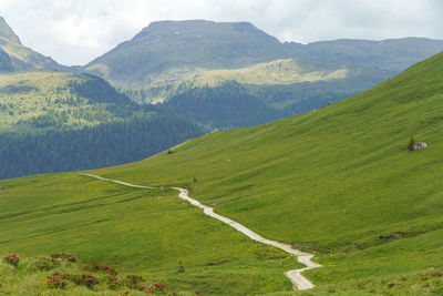 Scenic view of green landscape and mountains against sky