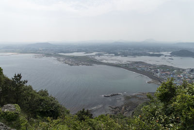 High angle view of sea and mountains against sky