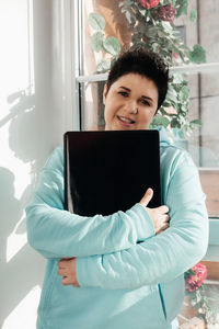 Portrait of smiling young woman using mobile phone