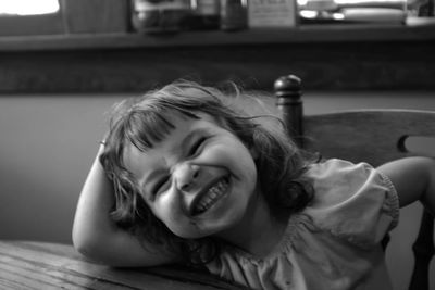 Happy girl making face while sitting on chair