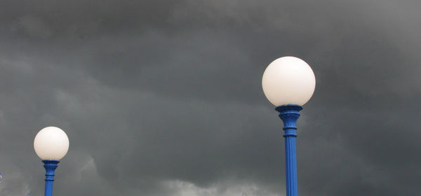 Low angle view of illuminated light bulb against sky