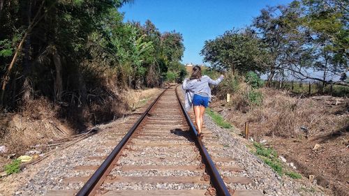 Railroad tracks amidst trees against clear sky