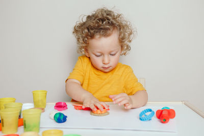 Boy child playing with sensor kinetic toy playdough. hand brain development. early age education.