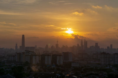 Buildings in city during sunset