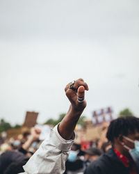 Rear view of people hand against clear sky