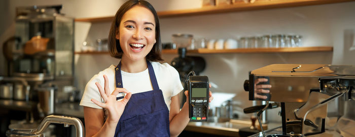 Portrait of young woman standing in cafe