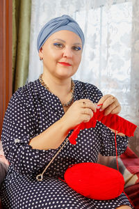 Portrait of smiling young woman holding gift box