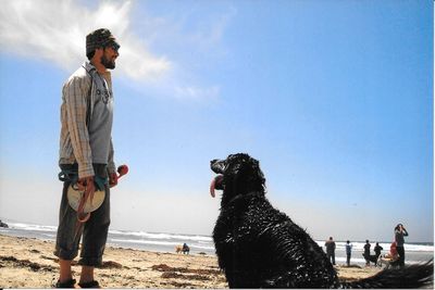 Man and dog playing on the beach