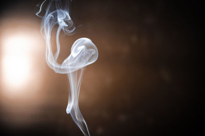 Abstract smoke from incense and light in a black background