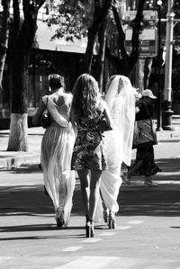 Rear view of women walking on road