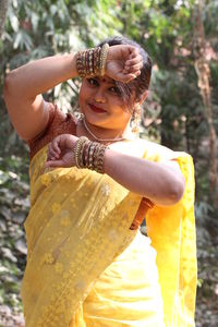 Portrait of smiling beautiful woman wearing yellow sari