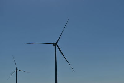 Low angle view of windmill against clear blue sky