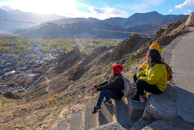 Women looking at view while sitting on mountain