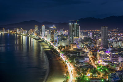 High angle view of illuminated city buildings against sky at night