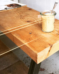 High angle view of sugar in glass container on table seen through window