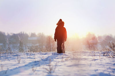 Person standing on snow covered field
