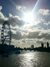 Sun shining through clouds over city