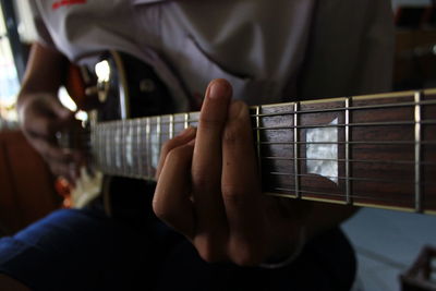 Close-up of man playing guitar