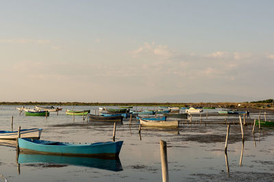 Boats moored on beach against sky