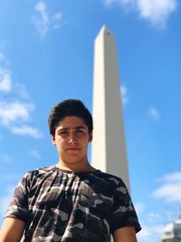 Low angle view of boy standing against obelisco de buenos aires