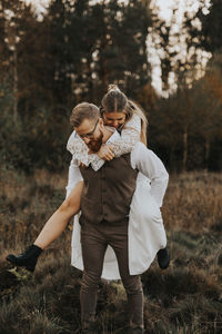 Rear view of couple kissing on field