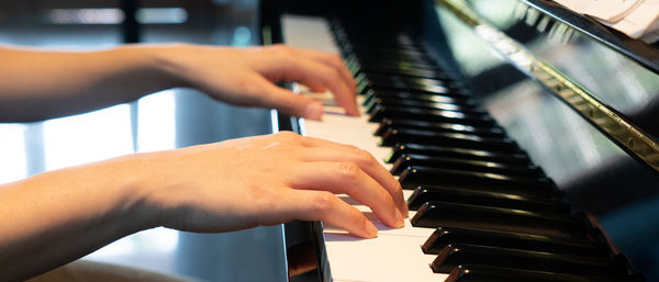 Midsection of man playing piano