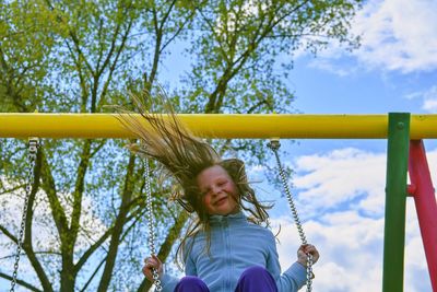 Girl swinging high. young child on swing outdoors. little blond girl having fun on a swing outdoor.