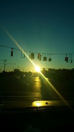 Cars on street against bright sun