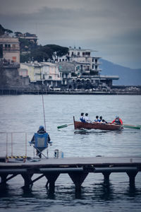Angler ans boat on mediterranean des against buildings in city