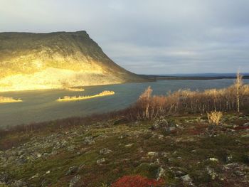 Scenic view of lake against cloudy sky