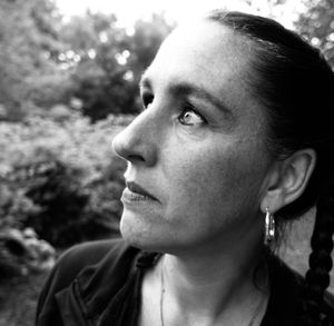 Close-up of woman looking away against trees