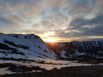 Scenic view of snowcapped mountains against sky during sunset