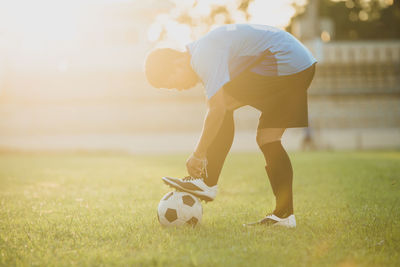 Man playing soccer ball on grass