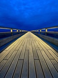 Surface level of footbridge against blue sky