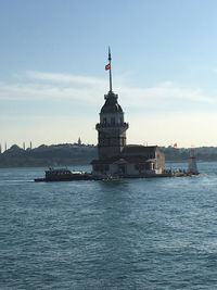 View of lighthouse by sea against sky