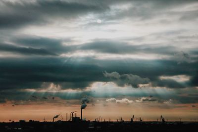 Silhouette of cityscape against dramatic sky