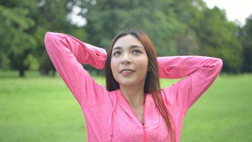 Portrait of woman with pink hair standing against plants