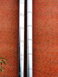 Close-up of pipe against brick wall