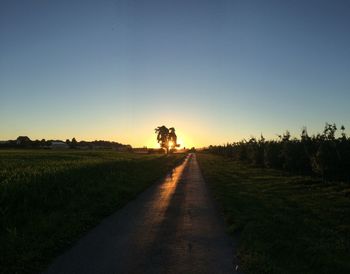 Scenic view of agricultural field against clear sky during sunset